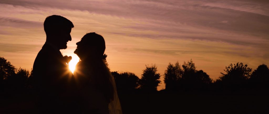 A still from wedding video with Bride and groom at the sunset at the Mythe Barn